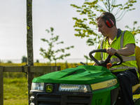 contractor using a John Deere to cut grass